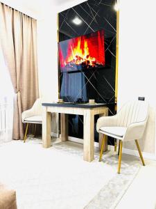 a living room with a table and a tv at Жк Панель центр in Fëdorovka