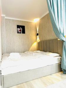 a bedroom with two beds with blue curtains at Жк Панель центр in Fëdorovka