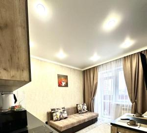 a living room with a couch in front of a window at Жк Панель центр in Fëdorovka