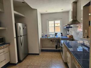 a kitchen with a stainless steel refrigerator and a sink at Bonito Depa céntrico in Jardines de la Hacienda