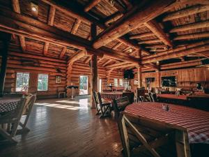 a dining room with tables and chairs in a wooden building at ÖBois Charlevoix - La Forgerie in Saint-Siméon
