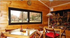 a dining room with a table and chairs and a window at Agroktima Armonia in Karpenisi