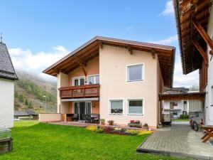 a house with a balcony and a yard at La Chiesa Lukas in Obergurgl