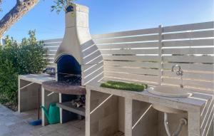 eine Außenküche mit einer Spüle und einem Pizzaofen in der Unterkunft Cozy Home In Marina Di Ragusa in Marina di Ragusa + 30 Fotos