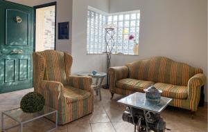 ein Wohnzimmer mit zwei Stühlen und einem Tisch in der Unterkunft Cozy Home In Marina Di Ragusa in Marina di Ragusa