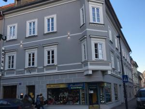 un grande edificio bianco all'angolo di una strada di Hotel SINOS a Klagenfurt