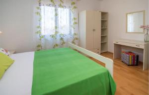 a bedroom with a bed with a green blanket on it at 1 Bedroom Beautiful Apartment In Vrbnik in Vrbnik +11 photos