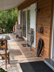 a wooden deck with chairs and a table on a house at le chalet des remparts in Aywaille