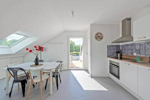 a kitchen and dining room with a table and chairs at Escapade à Combrit in Combrit