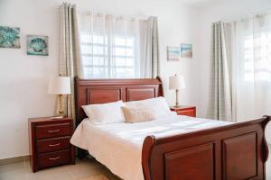 a bedroom with a large bed with white sheets and two lamps at Central apartment in Downtown Punta Cana in Punta Cana
