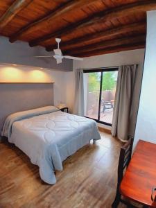a bedroom with a large bed and a large window at La Divina Pereza Eco in San Rafael