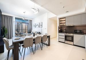a kitchen and dining room with a table and chairs at Downtown Luxe, steps to Burj Khalifa 4BDR in Dubai