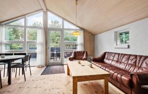 a living room with a couch and a table at Nice Home In Blåvand With Sauna in Blåvand