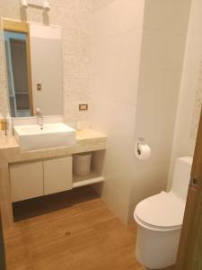 a white bathroom with a sink and a toilet at Hotel Vista Verde in Campoverde