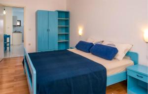 1 dormitorio con 1 cama azul y armario azul en 2 Bedroom Cozy Apartment In Vrbnik, en Vrbnik