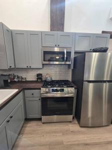 eine Küche mit einem Herd und einem Kühlschrank aus Edelstahl in der Unterkunft Dovetail Den - Tranquil with Hot Tub and Air Conditioning in Ashford