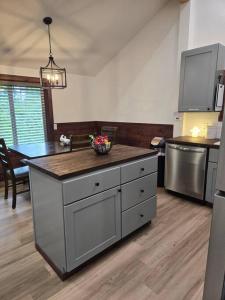 Eine Küche mit einer Kochinsel, auf der eine Obstschale steht. in der Unterkunft Dovetail Den - Tranquil with Hot Tub and Air Conditioning in Ashford + 29 Fotos