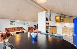 a kitchen and a living room with a table in a room at Nice Home In Blåvand With Sauna in Blåvand
