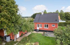 una casa roja con un patio delante en 3 Bedroom Gorgeous Home In Aakirkeby, en Åkirkeby 17 fotos más