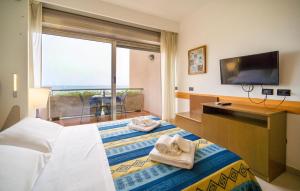 a hotel room with two beds and a television at Mono 2 in Lido di Mondello
