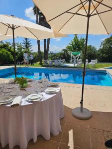 a table with glasses and umbrellas next to a pool at Retiro dos Cedros - Quarto Adega in Fogueira +35 photos