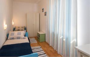 Una pequeña habitación con una cama y una ventana. en 2 Bedroom Cozy Apartment In Vrbnik, en Vrbnik 10 fotos más