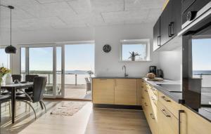 a kitchen with a dining room and a table with chairs at 2 Bedroom Cozy Home In Bjert in Bjert Strand