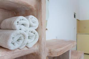 a pile of towels sitting on a wooden shelf at Parasporos Village in Adamas +66 photos