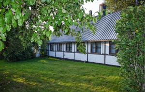 a white house with a gray roof and a yard at 2 Bedroom Beautiful Home In Glemmingbro in Hammar +11 photos