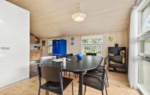 a dining room with a black table and chairs at Nice Home In Blåvand With Sauna in Blåvand