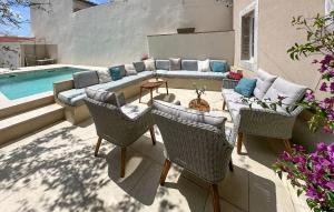 a patio with a couch and chairs next to a pool at Beautiful Home In Novi Vinodolski in Novi Vinodolski
