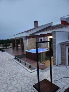 a house with a pool in the middle of a patio at Villa Melody Novalja in Novalja