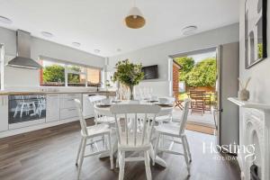 a kitchen and dining room with a white table and chairs at Fern House - Cosy 3 bedroom house with garden in Henley on Thames +9 photos