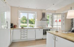 Una cocina con gabinetes blancos y una ventana grande. en 3 Bedroom Gorgeous Home In Aakirkeby, en Åkirkeby