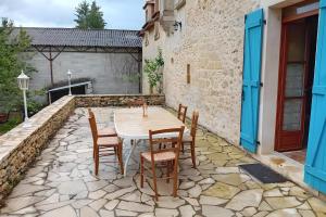 - une table et des chaises sur une terrasse en pierre dans l'établissement La Maison De Carmensac, à Meyrals