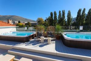 eine Terrasse mit zwei Stühlen und einem Swimmingpool in der Unterkunft Integra Hotel in Trebinje