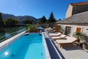 einen Pool mit Liegestühlen und ein Haus in der Unterkunft Integra Hotel in Trebinje