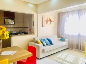 a living room with a white couch and a table at Flat Blumenau Vila Nova in Blumenau