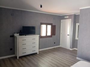 an empty room with a dresser and a television at La Sepia Boba (Adults only) in Peniscola
