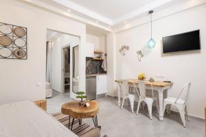 een eetkamer en woonkamer met een tafel en stoelen bij Ionas Apartments 1 in Nea Skioni