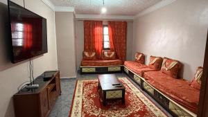 a living room with two couches and a tv at Villa SAAD in Khenchela