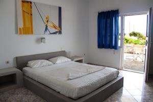 um quarto com uma cama e vista para um pátio em Parasporos Village em Adamas