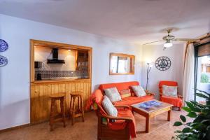 a living room with an orange couch and a table at Apartamento Atlanterra Playa in Zahara de los Atunes