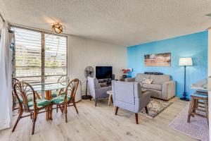 a living room with a table and chairs and a couch at Newly Remodeled Kailua-Kona Condo with Pool Access in Kailua-Kona