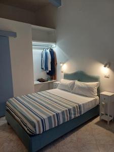 a bedroom with a bed with a striped bedspread and a window at Le Stanze del Mare - B&B in Messina