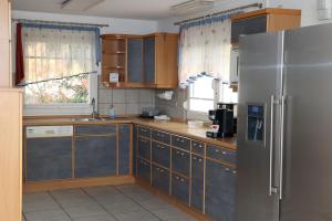 a kitchen with wooden cabinets and a stainless steel refrigerator at Lucky in Trossingen