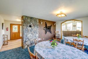 une pièce avec deux tables et un mur en pierre dans l'établissement Corvallis Coyote Creek House with Mountain Views!, à Corvallis