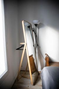 a mirror leaning against a wall next to a lamp at Paris Flea Market Comfy Flat in Saint-Ouen