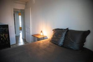 a bedroom with a bed and a table with a lamp at Paris Flea Market Comfy Flat in Saint-Ouen