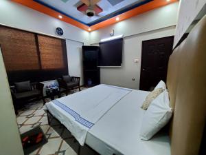 a bedroom with a large bed and a living room at Diplomat Inn Hotel in Karachi